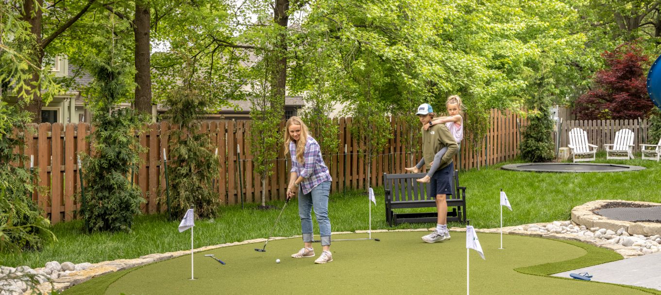 family practicing on artificial grass putting green